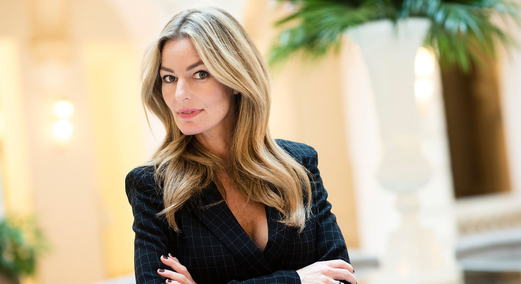 Business professional with long hair and confident expression.